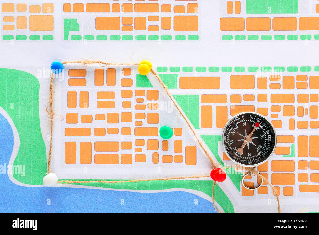 Stadtplan mit Reißzwecken und Kompass. Reiseplanung Stockfoto