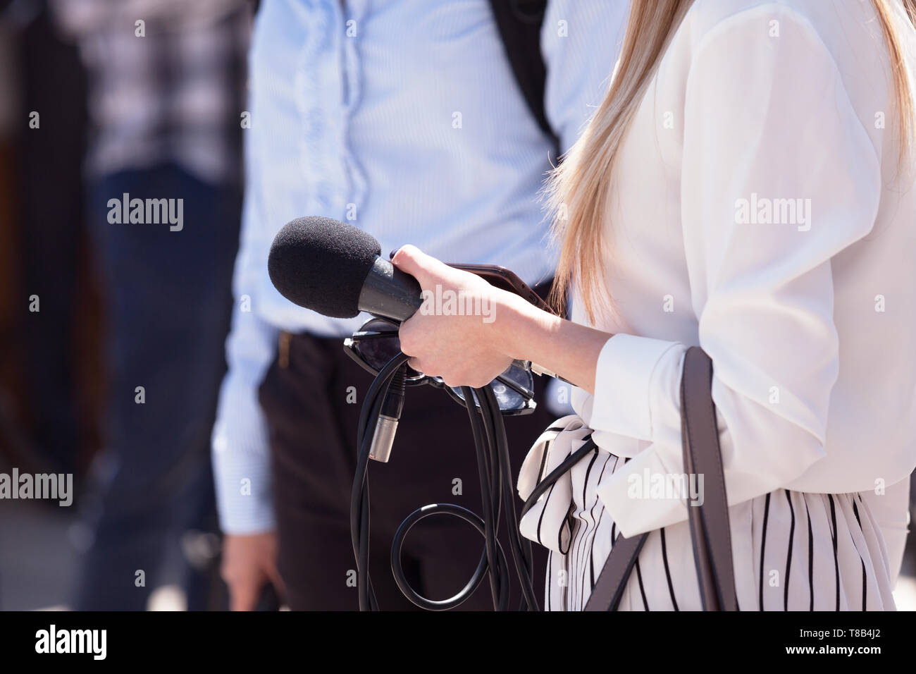 Weibliche Reporter mit Mikrofon an einem freien Medien event Stockfoto