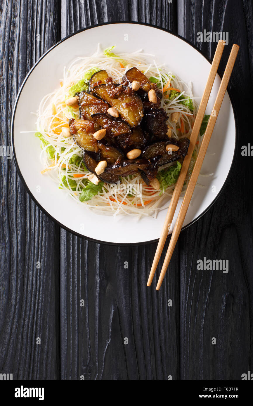 Asiatische Nudeln mit gebratenen Auberginen und Erdnüsse close-up auf einem Teller auf den Tisch. Vertikal oben Ansicht von oben Stockfoto