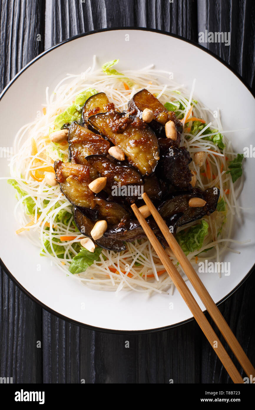 Vietnamesische Reisnudeln mit Auberginen und Erdnüsse close-up auf einem Teller auf den Tisch. Vertikal oben Ansicht von oben Stockfoto