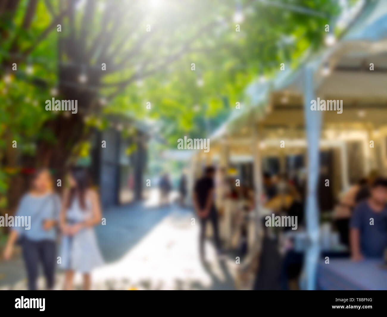 Abstrakte verschwommen Menschen zu Fuß auf Flohmarkt Hintergrund mit Sonnenlicht. Stockfoto