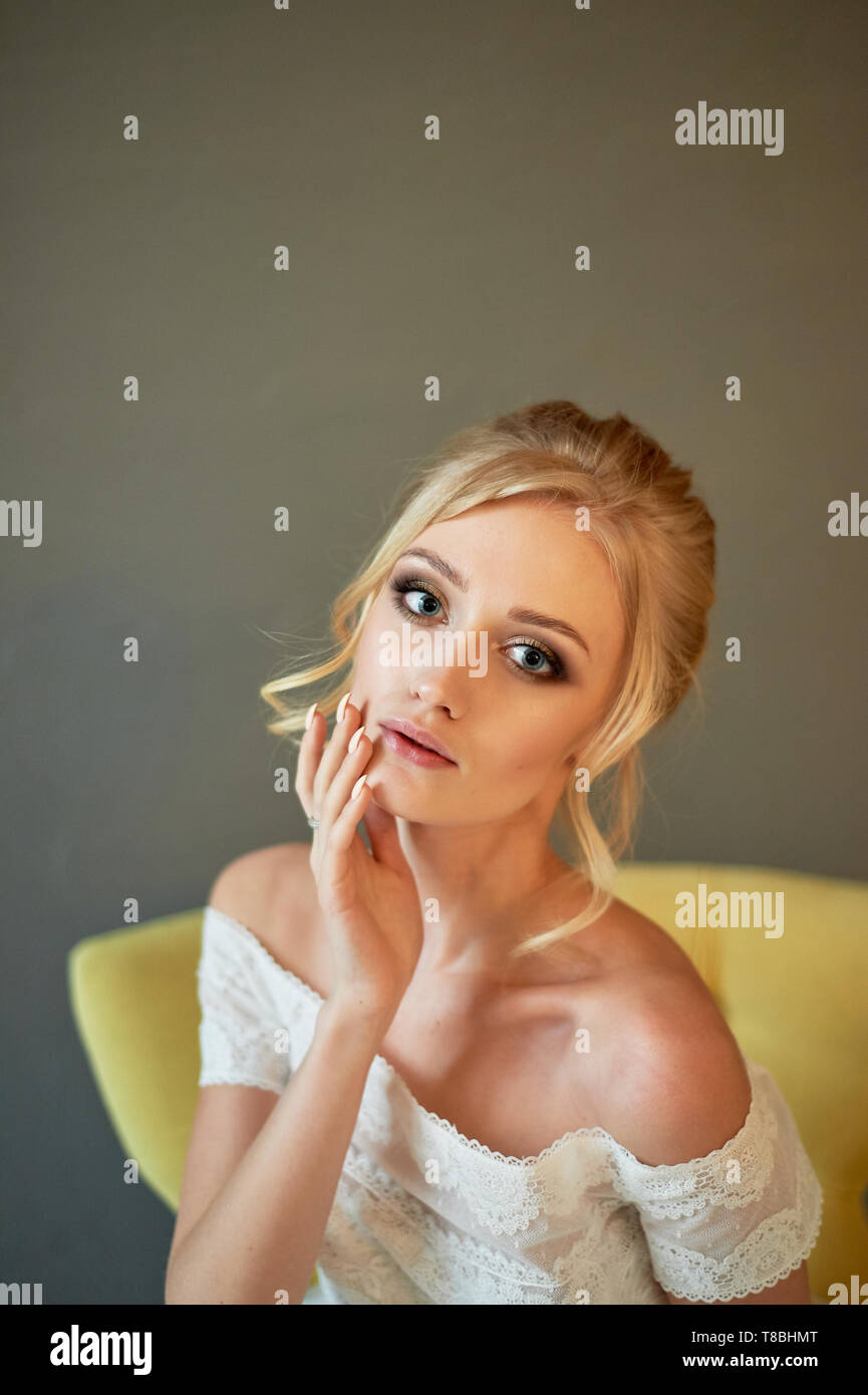 Porträt einer schöne Miniatur Braut in einem Spitzen Kleid. Haar mit Locken. Schwerpunkt in Make-up auf den Augen. Blond. Stockfoto