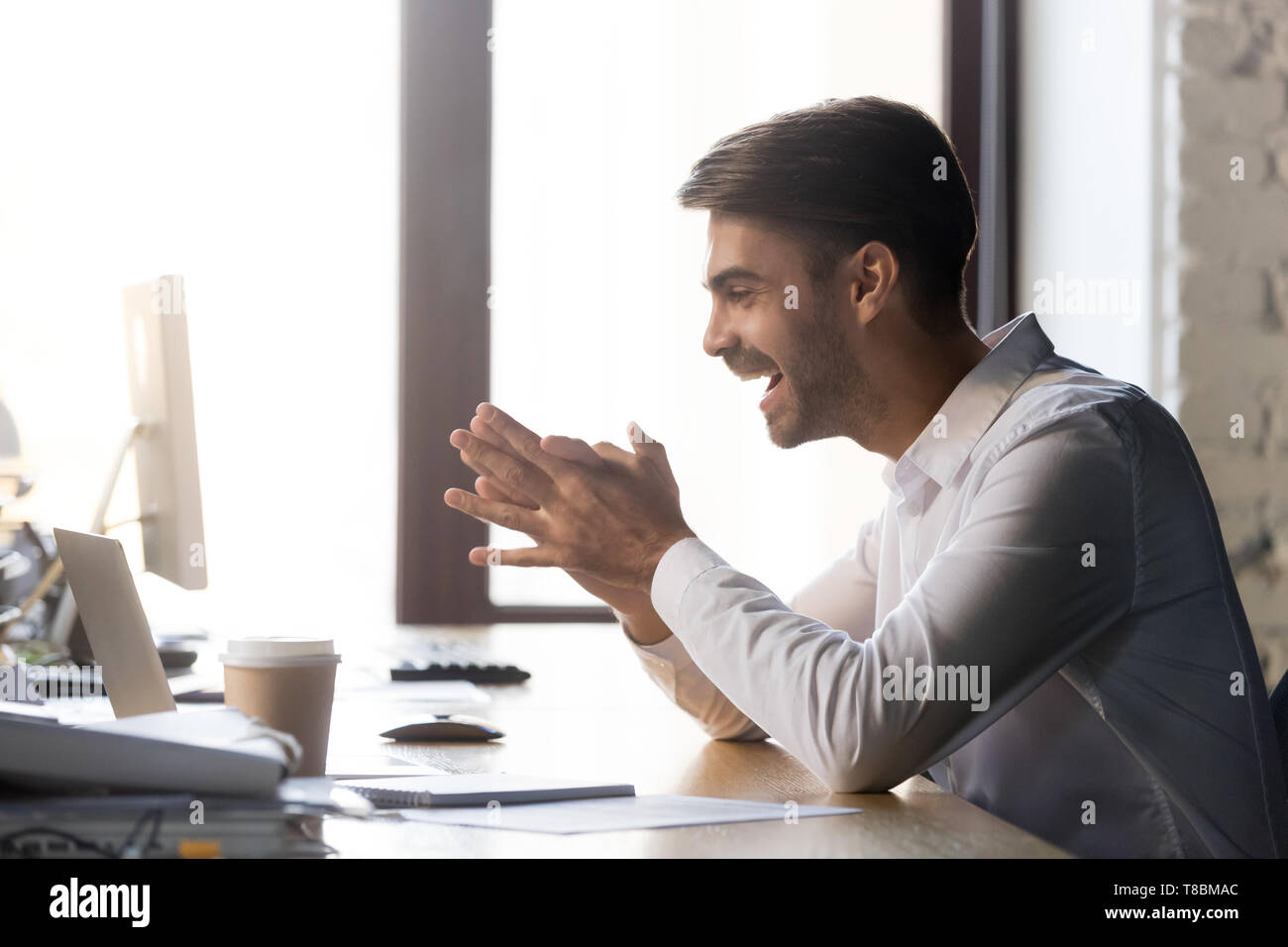 Büroangestellter Auslesen der empfangenen Nachricht an Computer fühlt sich glücklich Stockfoto