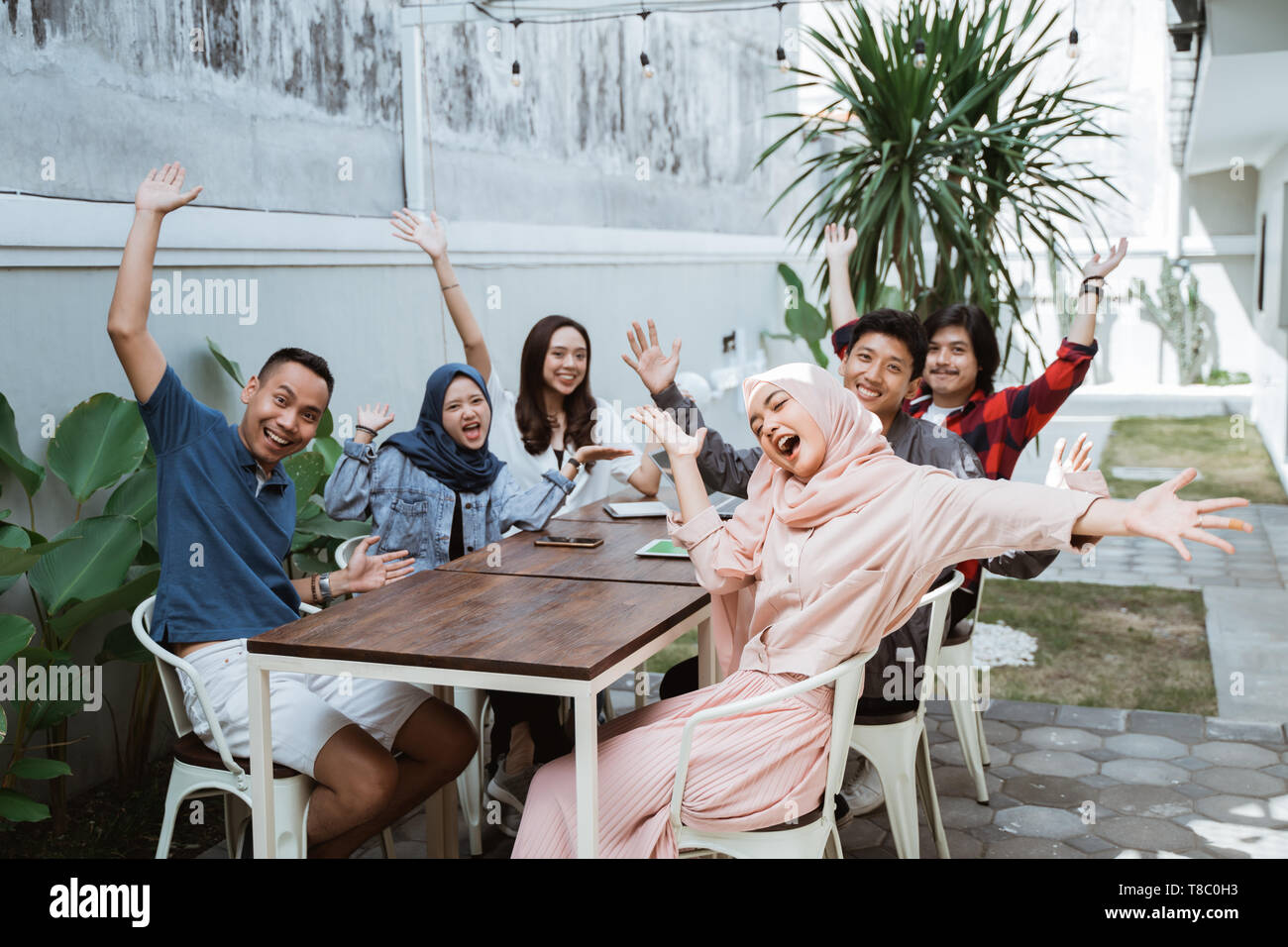 Gruppe von Freunden genießen sammeln mit hands up Stockfoto