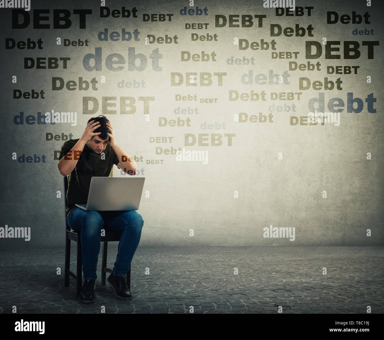 Verärgert und junger Mann mit Laptop auf einem Stuhl sitzt, betonte, halten sich an den Händen zu Kopf, hat emotionalen Schock über sehr große Schuld. Enttäuscht Freelance Stockfoto