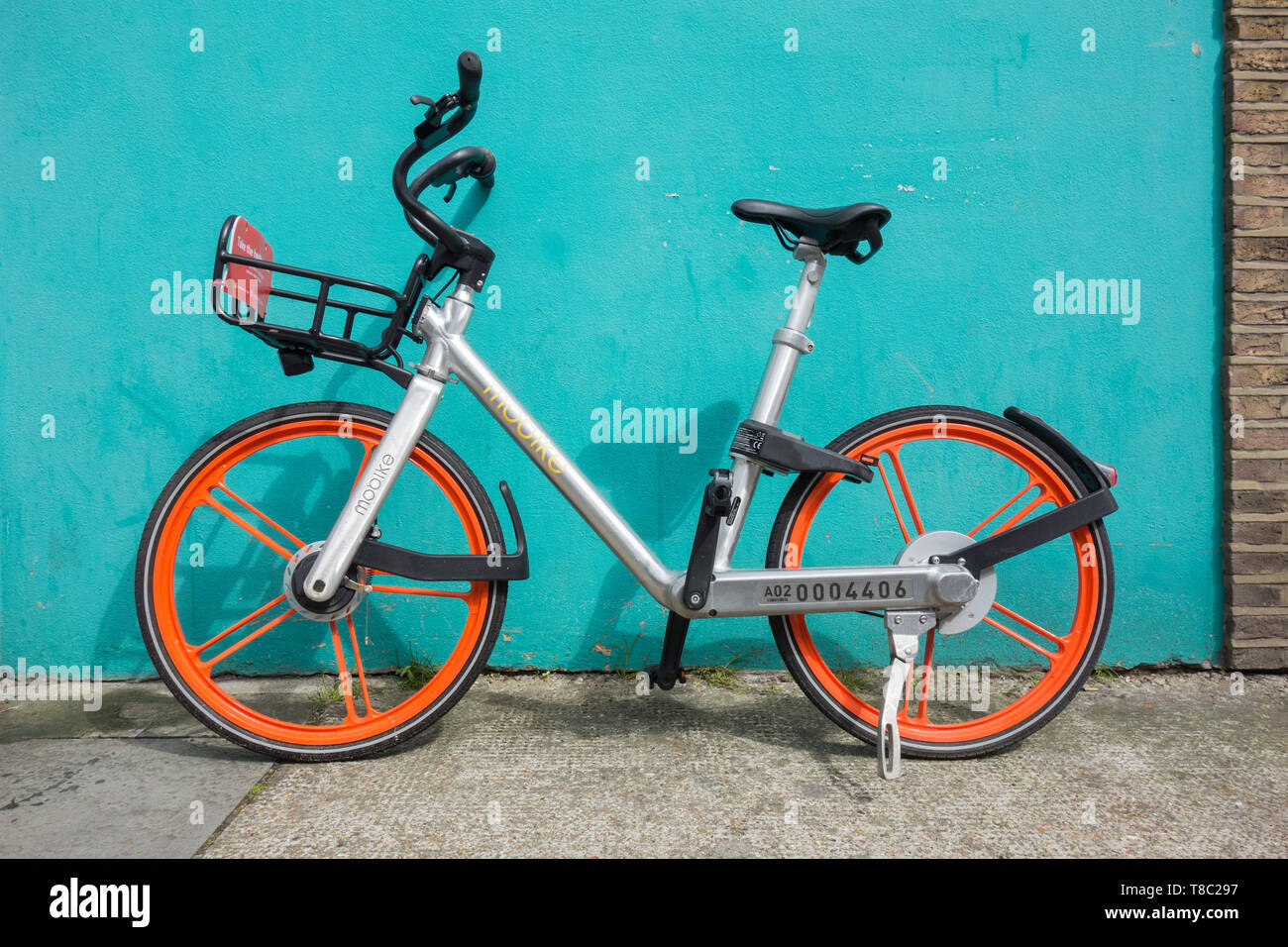 Eine chinesische Mobike Fahrrad gegen eine Azure Wand auf einer Straße in London, Großbritannien Stockfoto