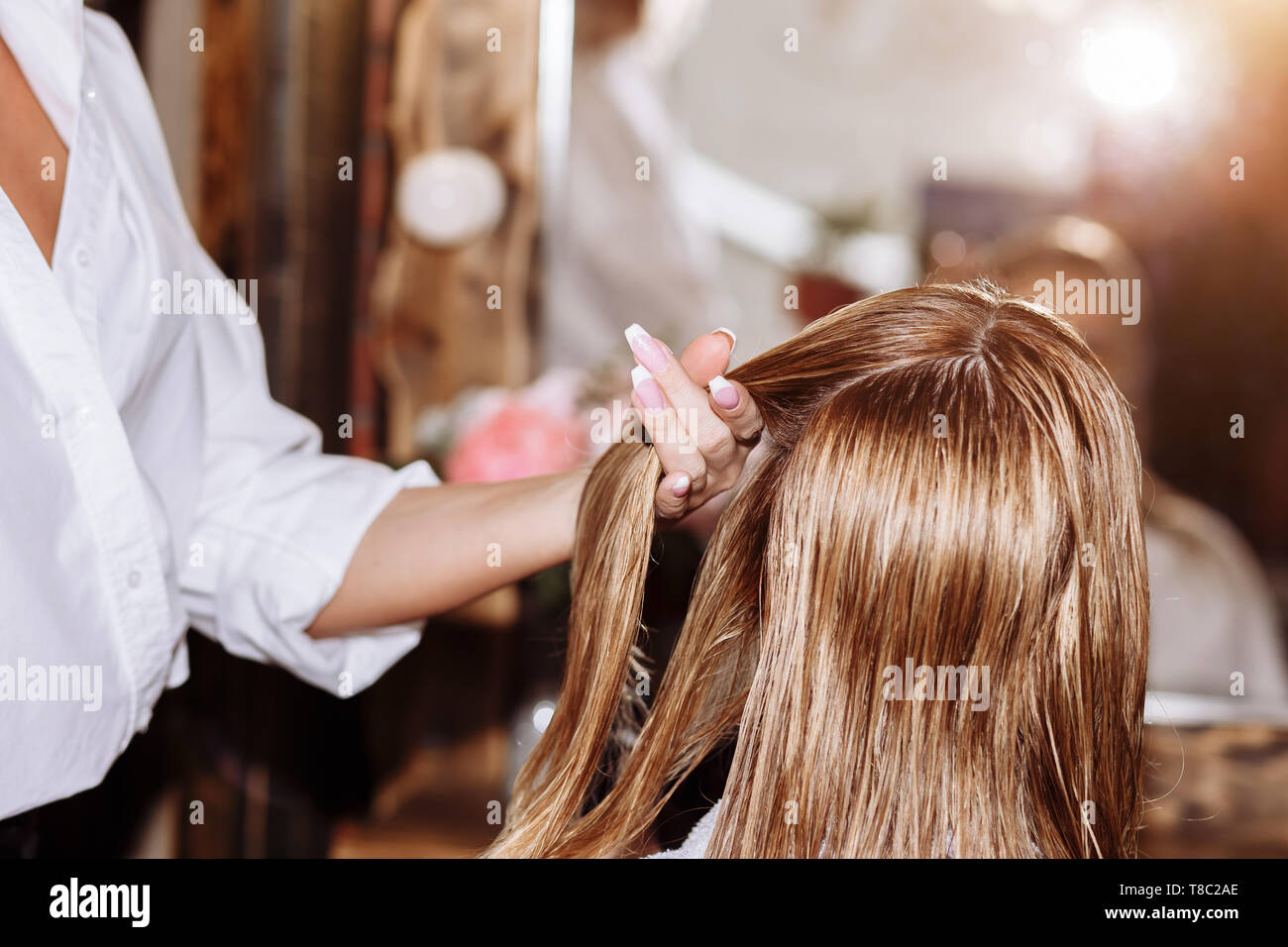 Nahaufnahme des professionellen Friseur mit Bürste und Haartrockner styling  lange blonde Haare ihrer weiblichen Kunden. Gesund glänzendes Haar der Frau  nach Haar tre Stockfotografie - Alamy