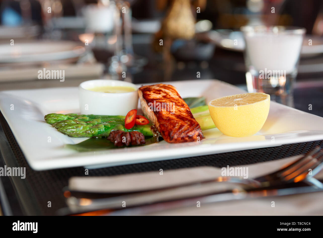 Lachssteak im asiatischen Stil am Tisch im Restaurant zubereitet Stockfoto