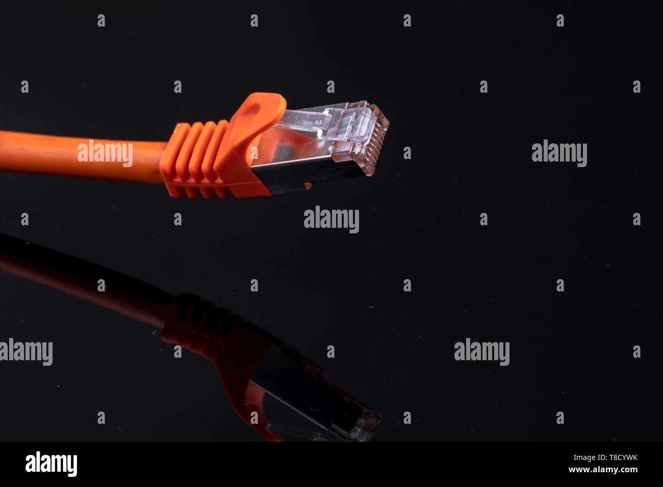 Orange Datenkabel für schnelles Internet auf schwarzem Hintergrund für eine moderne Installation in Ihrem Zuhause Stockfoto