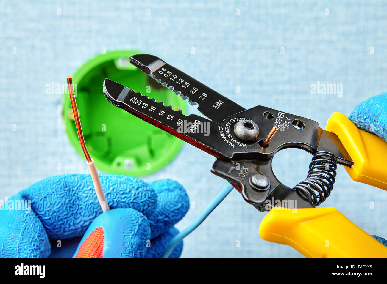 Montage von runden Anschlussdose, Schneiden von Drähten mit Hilfe von abisolierzange Seitenschneider, elektrische Arbeit. Stockfoto