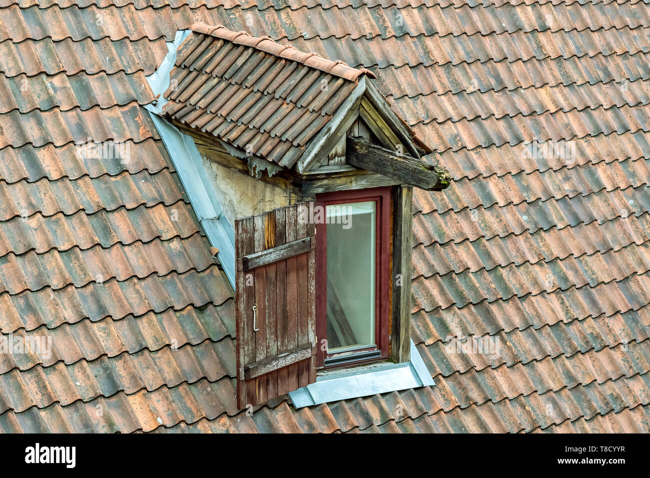 Die Fensterläden auf dem Dachboden öffnen, auf dem alten Dach des roten Fliesen. Stockfoto