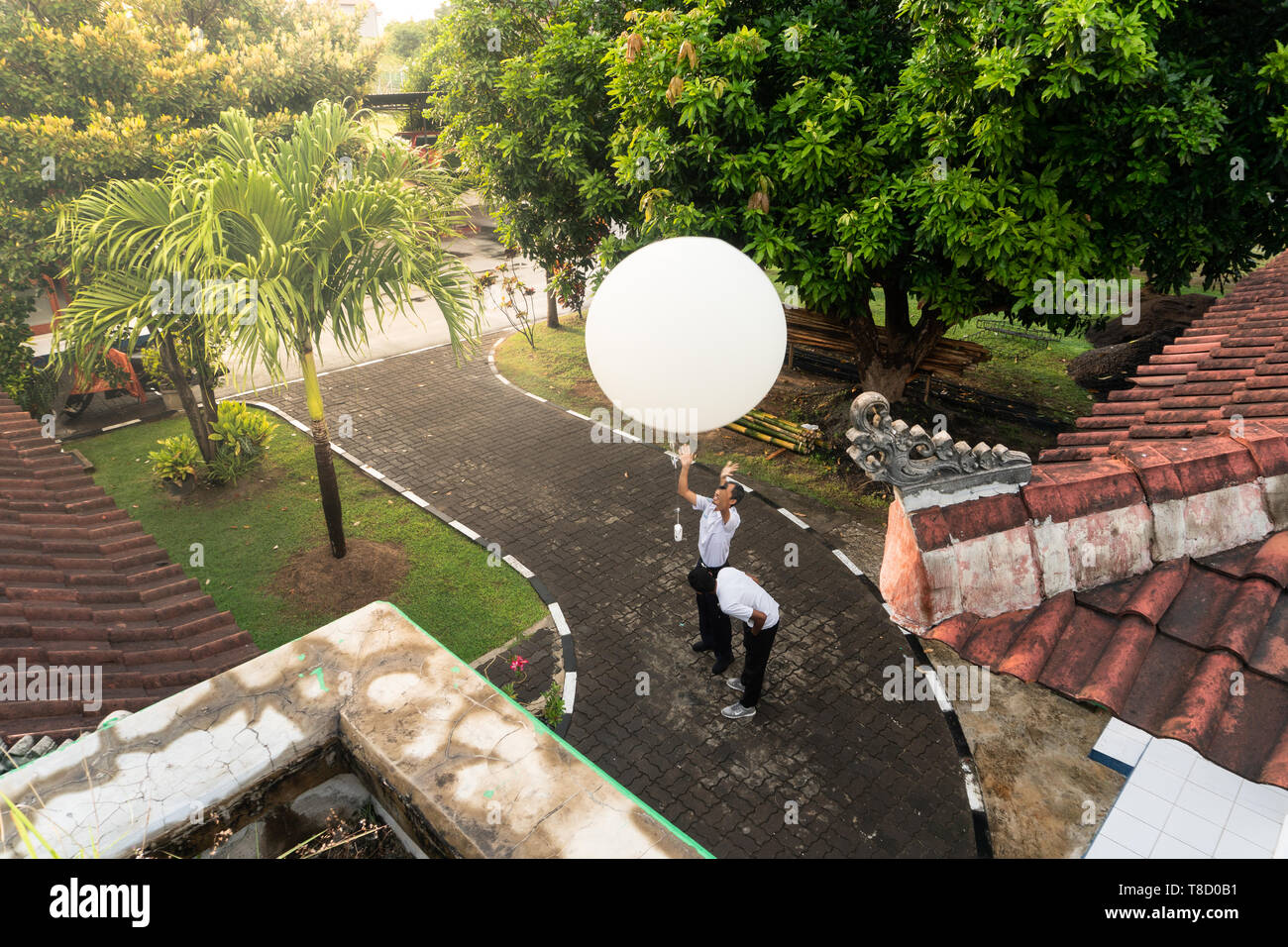 BADUNG BALI - 10. APRIL 2019: Ein Beobachter am Ngurah Rai meteorologische Station lösen der großen weißen Radio sonde Ballon zu messen die Labilität der Stockfoto