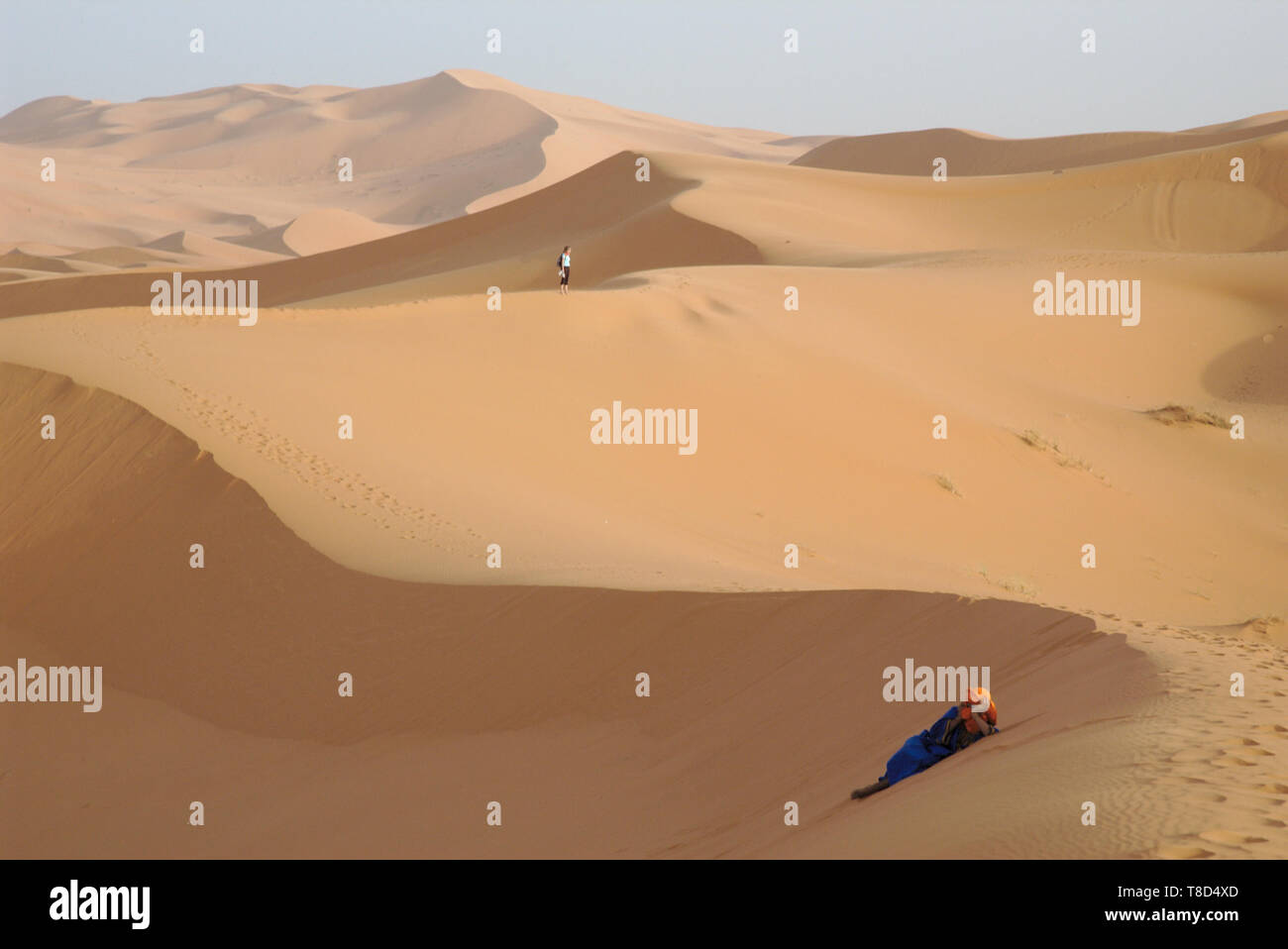 Landschaft in der Wüste Erg Chebbi in Marokko mit Tuareg im Sand und touristische Wanderungen in der Ferne. Stockfoto