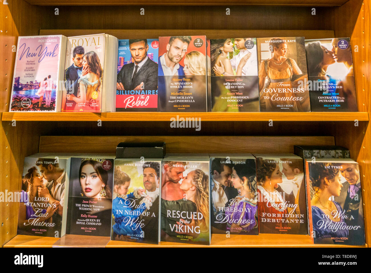 Eine Auswahl an Mills & Boon Taschenbuch romantische Romane und historische Romane, angezeigt im Verkauf in einer Buchhandlung. Stockfoto