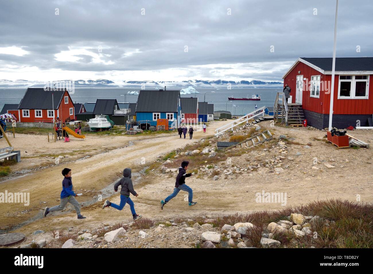 Grönland, North West Coast, oder Neue Thule Qaanaaq, Inuit Kinder führen ihre Lehrerin, ein Eisberg im Hintergrund Stockfoto