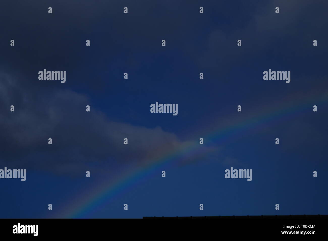 Regenbogen auf einem dunklen Himmel Stockfoto