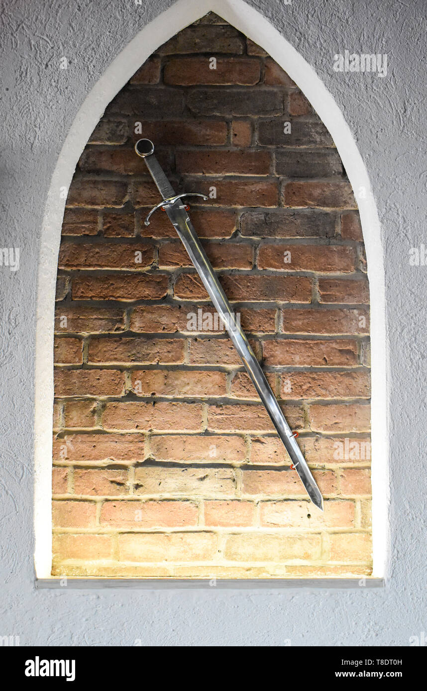 Mittelalterliche stahl Schwert gegen die Mauer Hintergrund. Alte leuchtendes Schwert als Dekoration verwendet werden Stockfoto