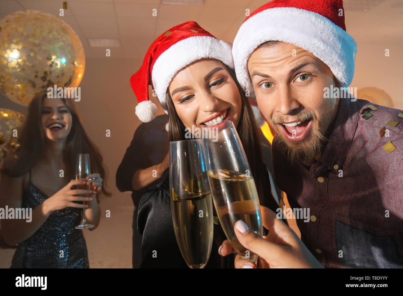 Junge Menschen mit Gläser Champagner an der Weihnachtsfeier Stockfoto