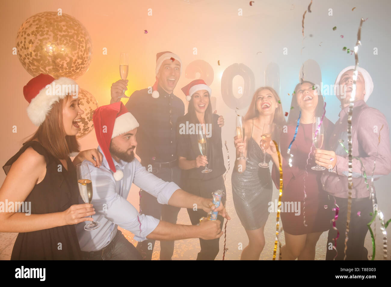 Junge Menschen mit Gläser Champagner an der Weihnachtsfeier Stockfoto