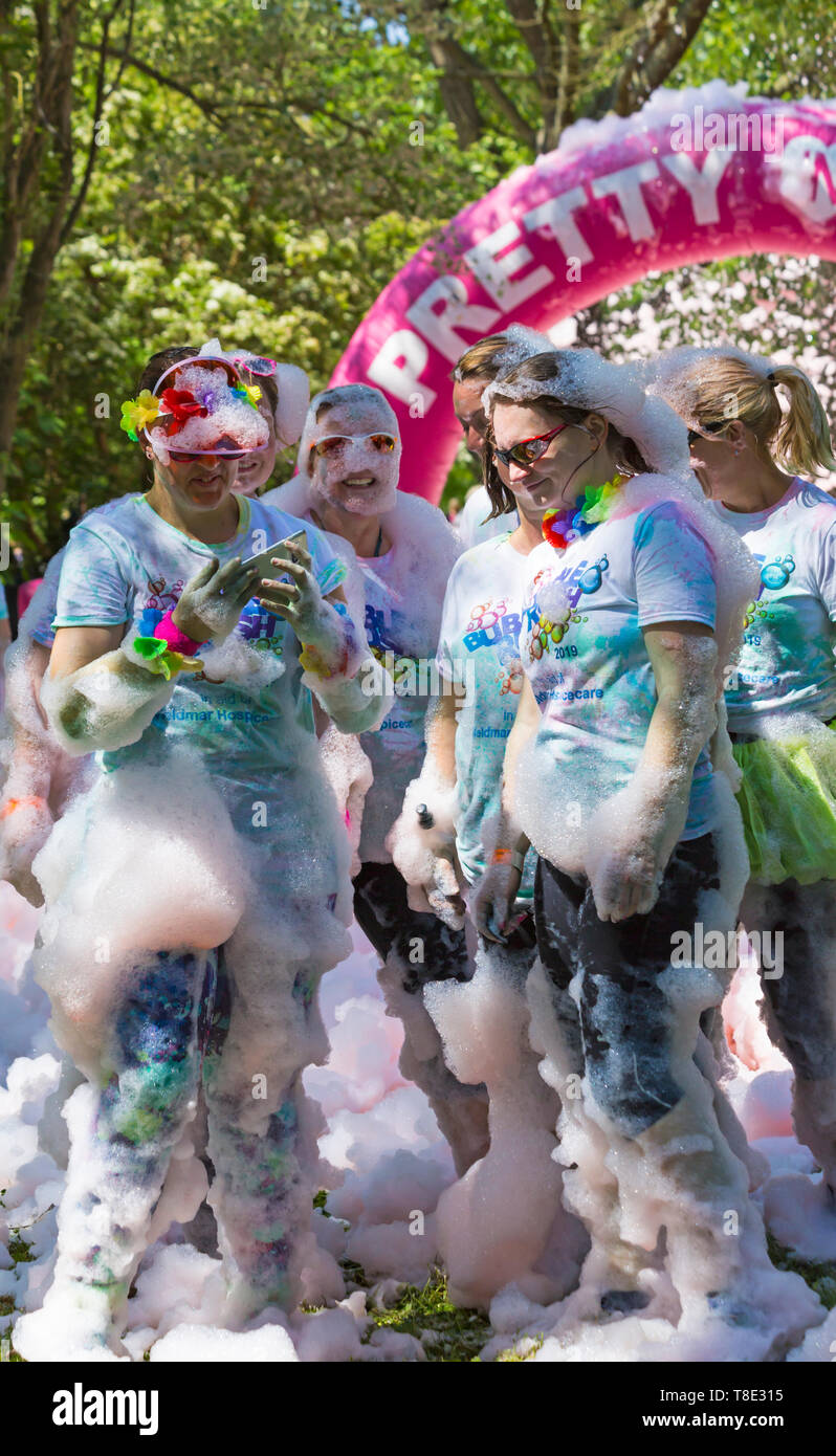 Dorchester, Dorset, Großbritannien. 12. Mai 2019. Weldmar des letzten jemals Bubble Rush erfolgt in Weymouth Mittel für die Nächstenliebe zu erhöhen. Die Teilnehmer haben Spaß, der in Schaum bedeckt, die durch Blasen in verschiedenen Farben. Credit: Carolyn Jenkins/Alamy leben Nachrichten Stockfoto