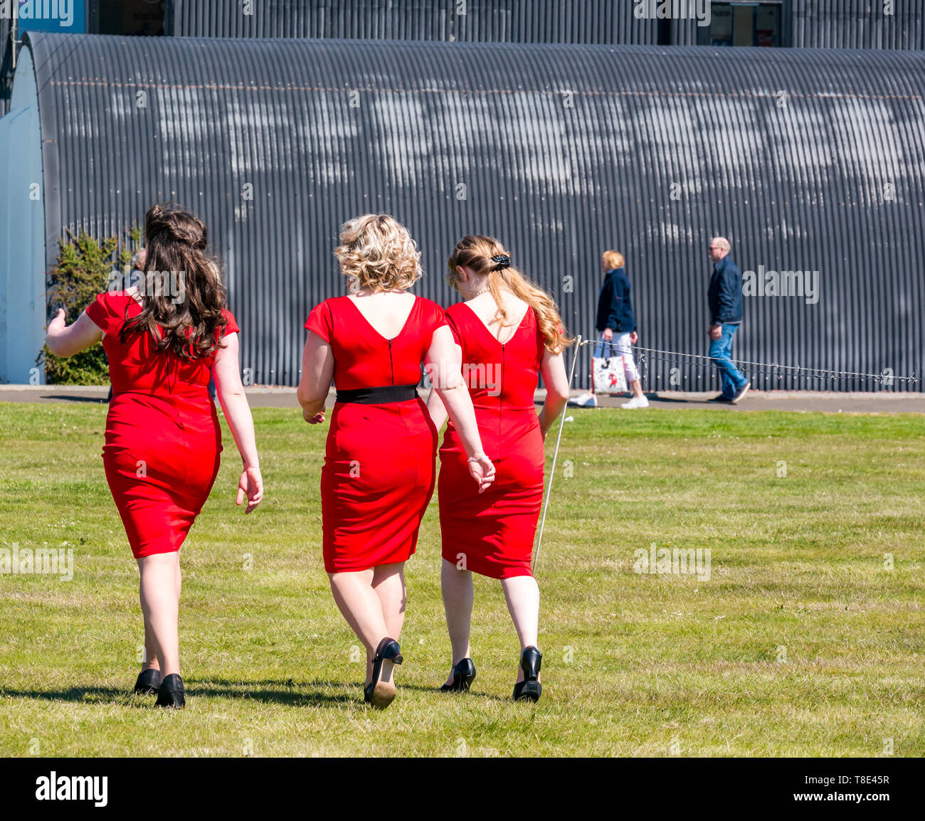 East Lothian, Großbritannien. 12th Mai 2019. Kriegserfahrung: Frauen in roten Kleidern, die Ragtime Dolls Sänger, die über ein Feld gehen Stockfoto