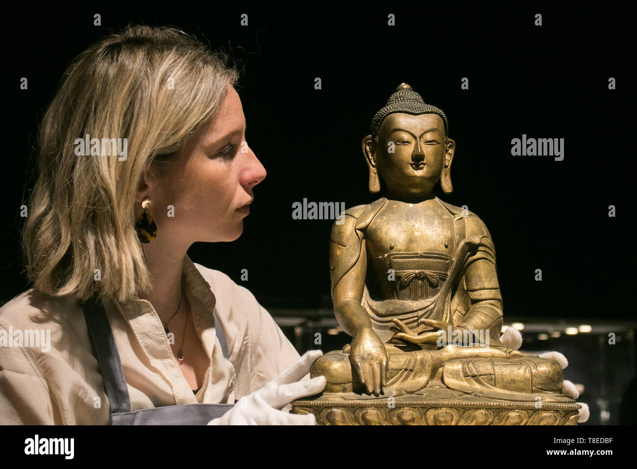 London, Großbritannien. 13. Mai, 2019. Ein bonhams Assistant schaut auf eine wunderschöne und große vergoldete Bronze Figur von Buddha Shakyamuni. 17./18. Jahrhundert. £ 80,000-120,000 Foto Aufruf zur feinen chinesischen und japanischen Vertrieb bei Bonhams New Bond Street Credit: Amer ghazzal/Alamy leben Nachrichten Stockfoto