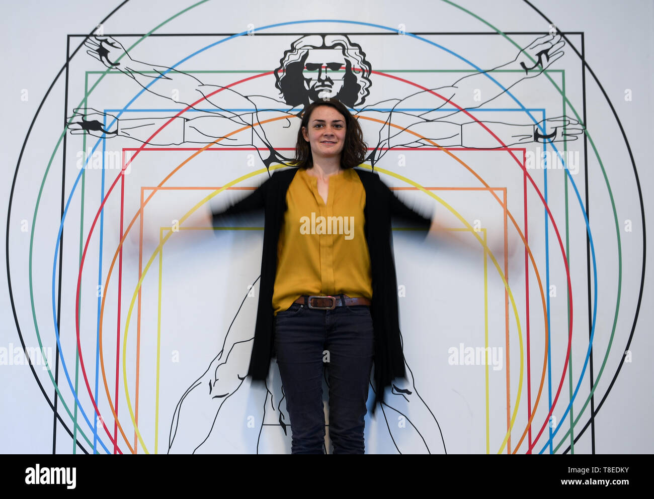 Hessen, Deutschland. 13 Mai 2019, 13. Mai 2019, Hessen, Gießen: Lisa Peter, Mitarbeiter der interaktive Museum 'Mathematikum", steht in der ständigen Ausstellung vor dem Bild des Leonardo Mann, ein "Anteil Studie nach Vitruv". Besucher können in der Ausstellung "Auf den Spuren von Leonardo da Vinci zu berühren. An rund 20 Stationen und Ausstellungen, Sie können es ausprobieren, ob die Maschinen gezeichnet von der Renaissance Künstler wirklich Arbeiten und was verbirgt sich hinter seine Ideen. Die Show "Leonardo in das Mathematikum" vom 18. Mai 2019 bis zum 29. März 2020. Quelle: dpa Picture alliance/Alamy leben Nachrichten Stockfoto