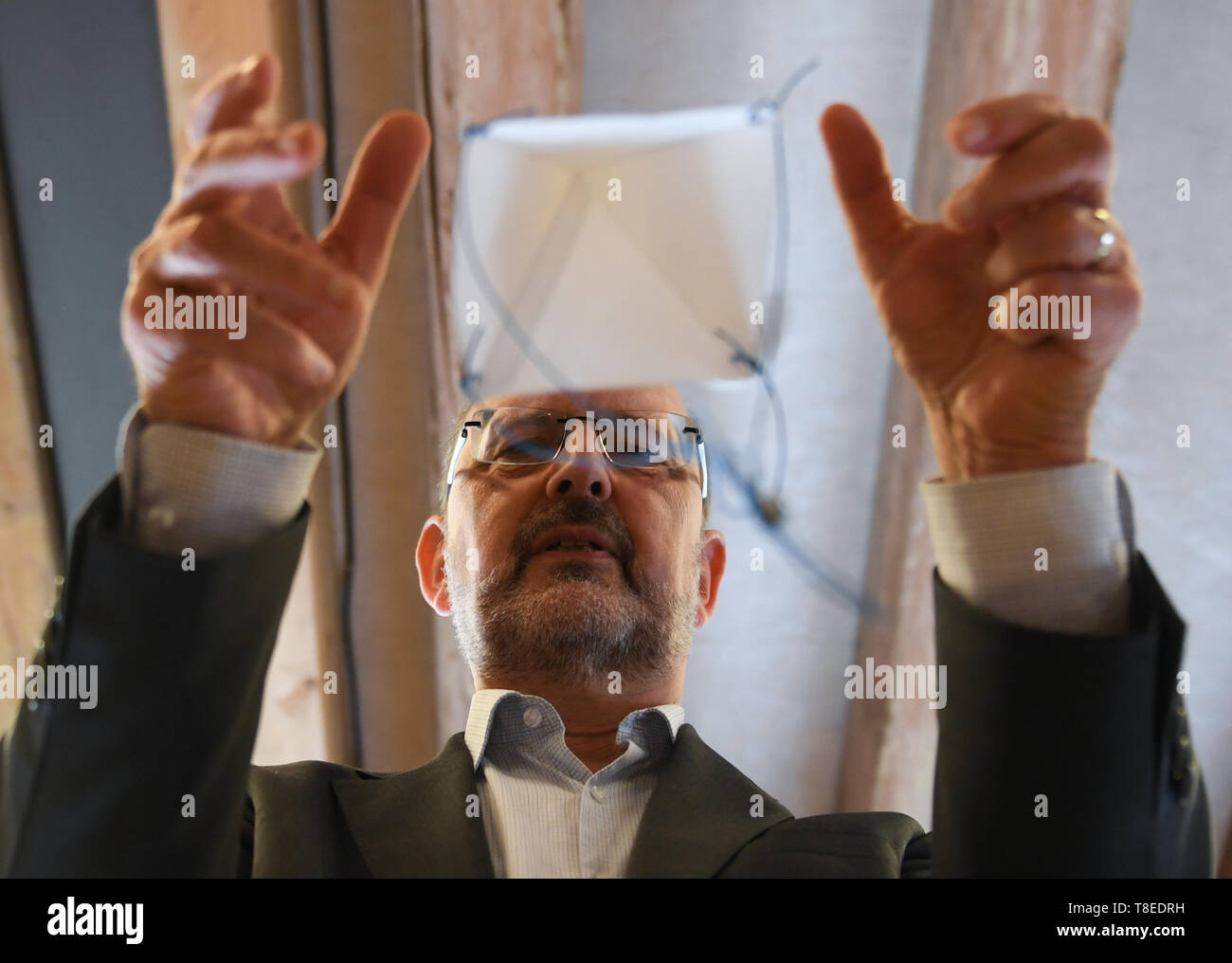 Hessen, Deutschland. 13 Mai 2019, 13. Mai 2019, Hessen, Gießen: Albrecht Beutelspacher, Direktor des interaktiven Museums 'Mathematikum", präsentiert ein da Vinci Fallschirm in einer Sonderausstellung. Besucher können in der Ausstellung "Auf den Spuren von Leonardo da Vinci zu berühren. An rund 20 Stationen und Ausstellungen, Sie können es ausprobieren, ob die Maschinen gezeichnet von der Renaissance Künstler wirklich Arbeiten und was verbirgt sich hinter seine Ideen. Die Show "Leonardo in das Mathematikum" vom 18. Mai 2019 bis zum 29. März 2020. Quelle: dpa Picture alliance/Alamy leben Nachrichten Stockfoto