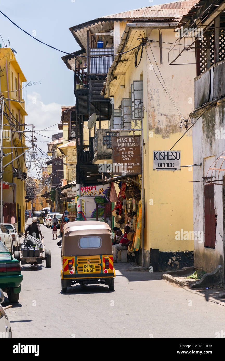 Typische Ansicht der Gebäude auf einer Seitenstraße als tuk tuk Antriebe Vergangenheit in der Altstadt von Mombasa, Kenia Stockfoto