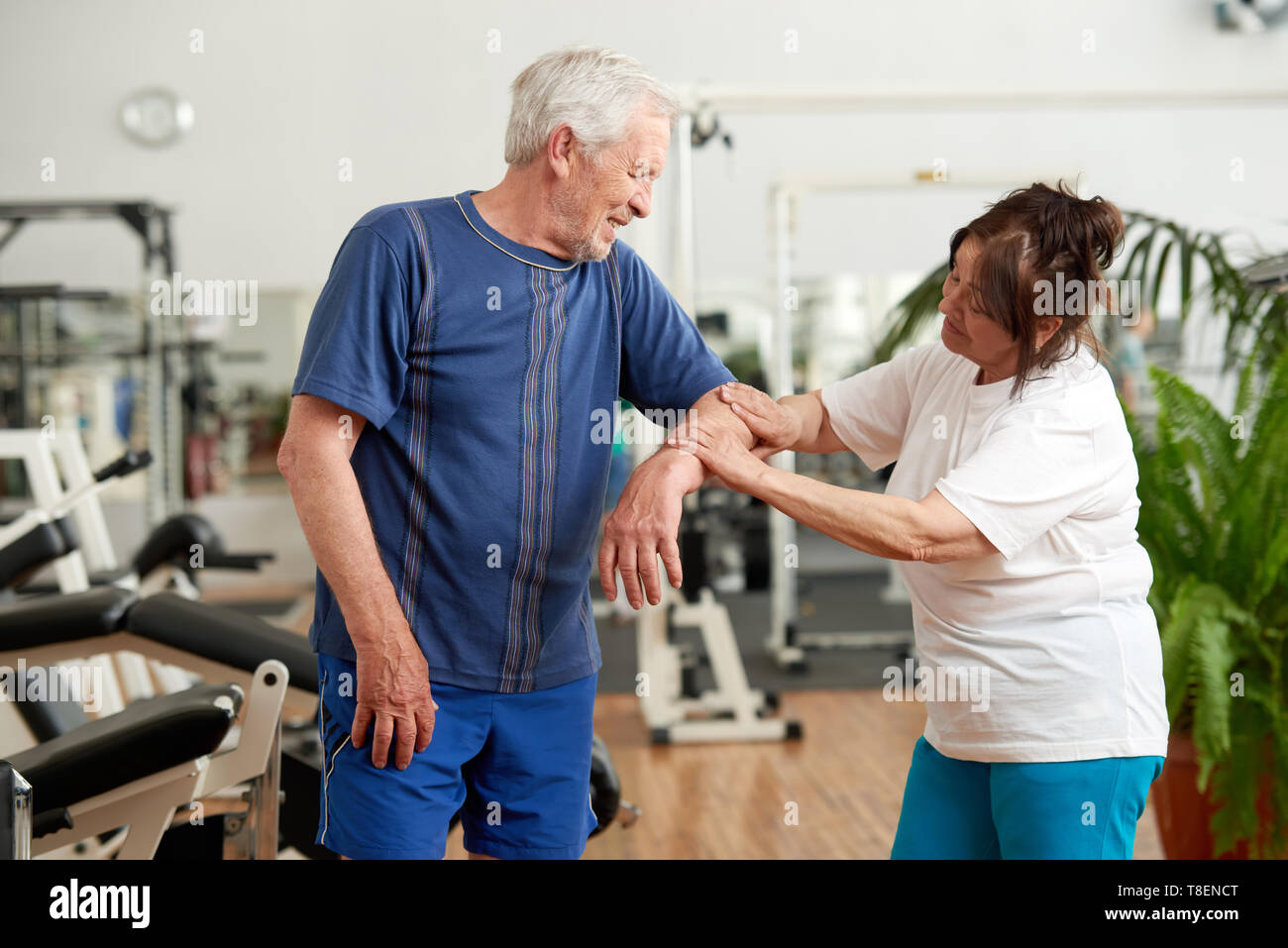 Ältere Menschen Gefühl Schmerz im Ellenbogen während des Trainings. Ältere Frau mit verletzten Arm des Menschen im Fitnessstudio. Menschlichen Ausdruck von Schmerz. Stockfoto