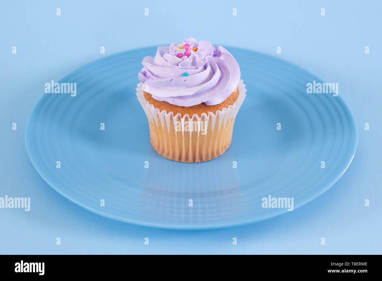 Single Cupcake auf blauen Platte. Stockfoto