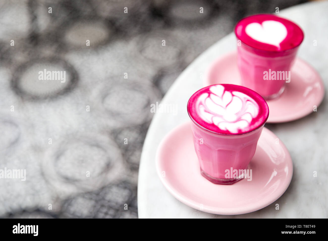 Zwei Gläser rosa Rote Beete Latte mit schönen Latte Art auf Marmor tisch Hintergrund. Trendy gesundes Getränk. Stockfoto