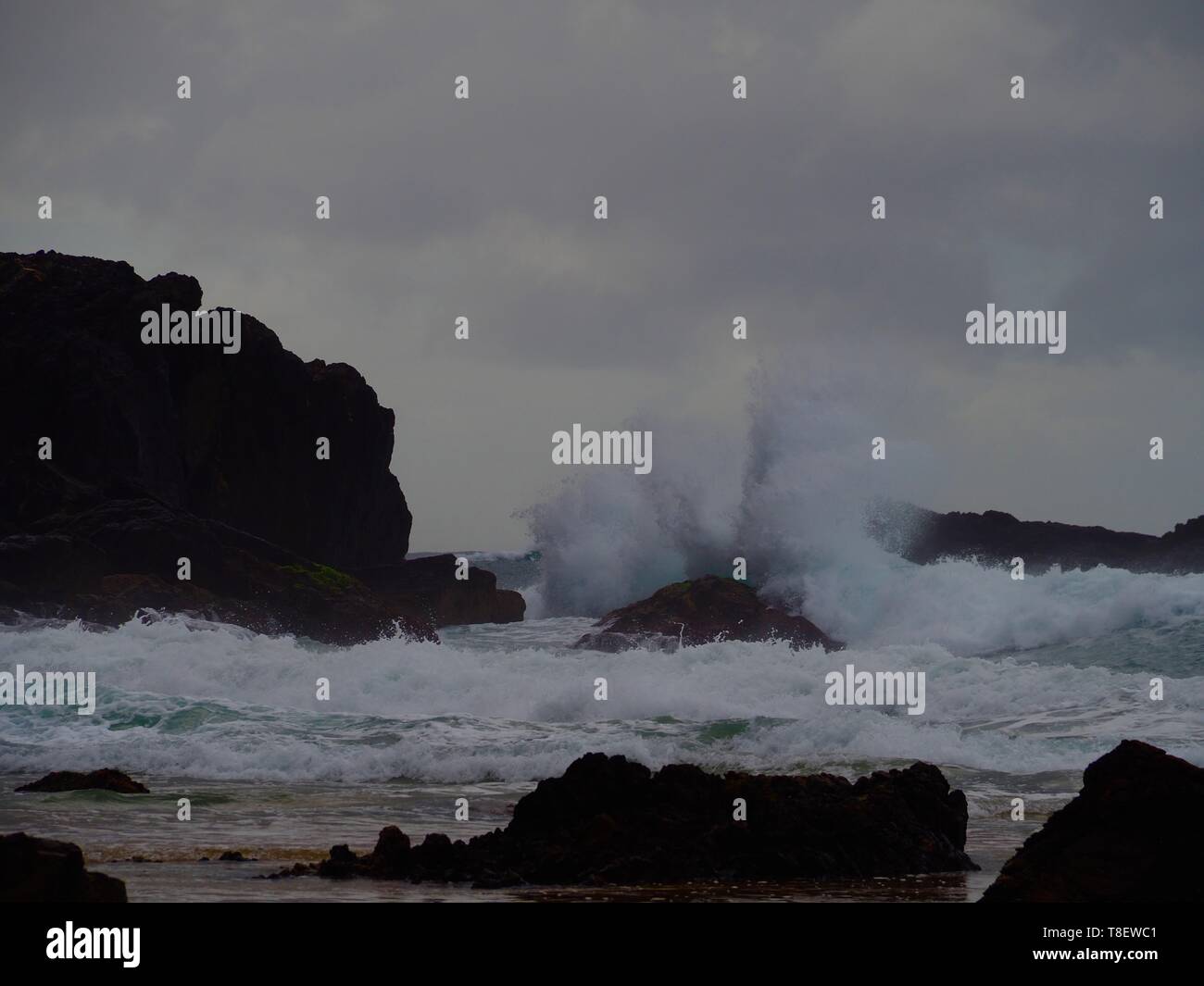 Die Wellen gegen die Felsen am australischen Strand explodieren Stockfoto