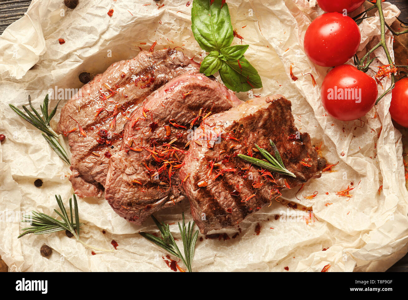 Köstliche gegrillte Steaks auf Pergament Stockfoto