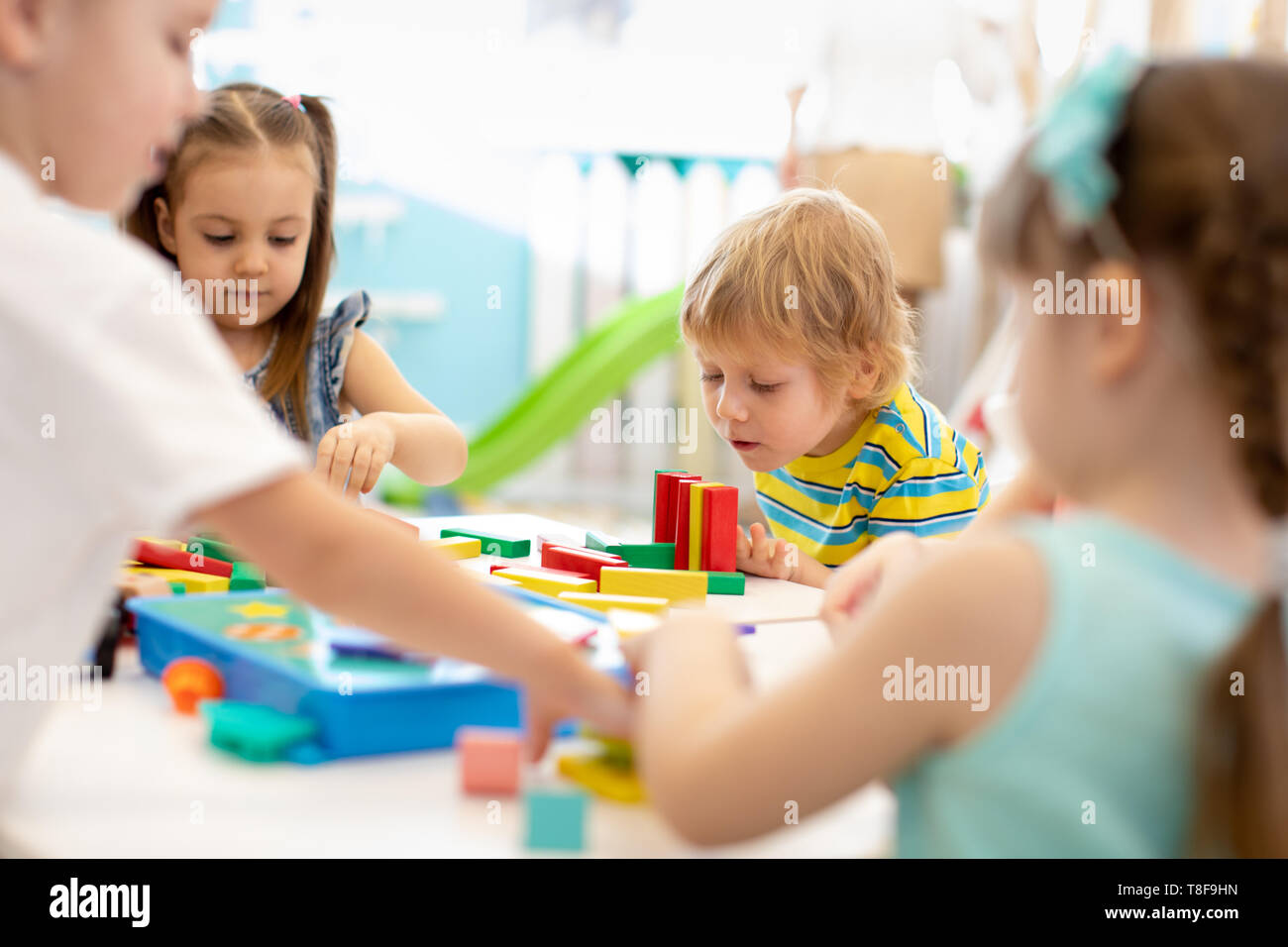 Gruppe der Kindergarten Kinder in der Kindertagesstätte. Glückliche Kinder spielen mit Kunststoff Bausteine Kindergarten Stockfoto