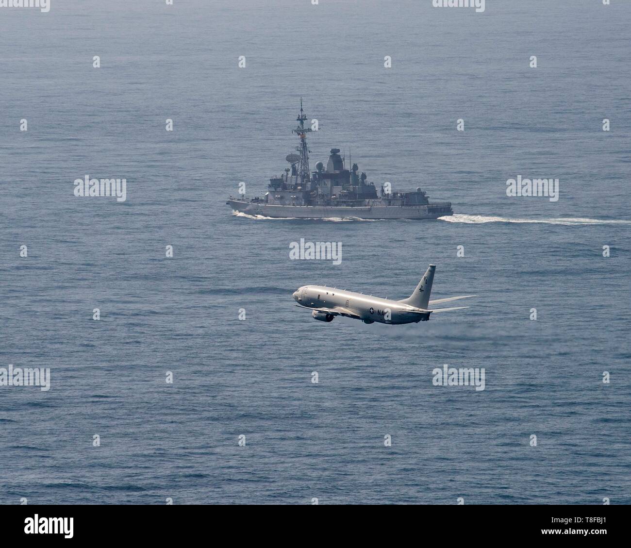 Ein U.S. Navy P-8 Poseidon Flugzeug fliegt neben der Französischen Marine Nationale Anti-Zerstörer FS Jean Bart beim Übergang über die Meerenge von Gibraltar in den Atlantik nach einem sechsmonatigen Einsatz Mai 3, 2019 vor der Küste von Spanien. Stockfoto