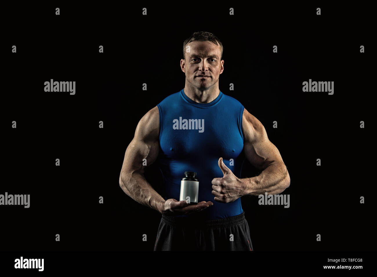 Essen und Ernährung für Sport und Fitness. Sportler mit Vitamin Flasche  zeigen Daumen nach oben. Nahrungsergänzung für Bodybuilder. Energie und  Wellness Konzept, vintage Stockfotografie - Alamy