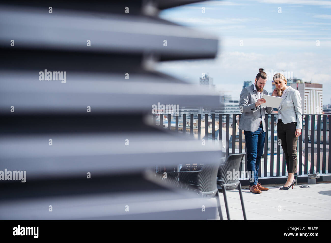 Zwei junge Geschäftsleute mit Tablet steht auf einer Terrasse im Freien, Büro, arbeiten. Stockfoto