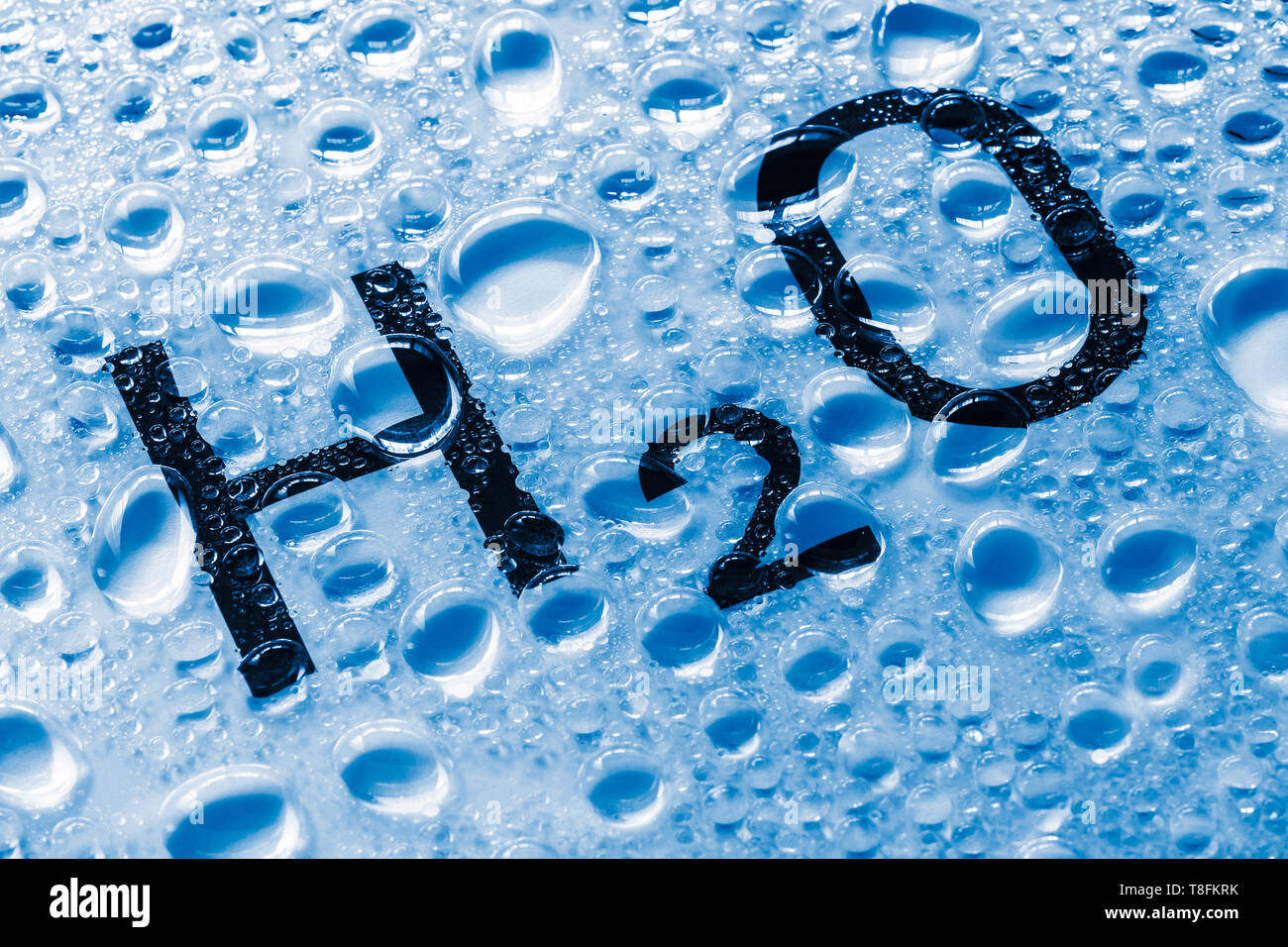 Die chemische Formel von Wasser mit Tropfen auf dem Glas. Reines Wasser Konzept. Natürliche Ressourcen. Stockfoto