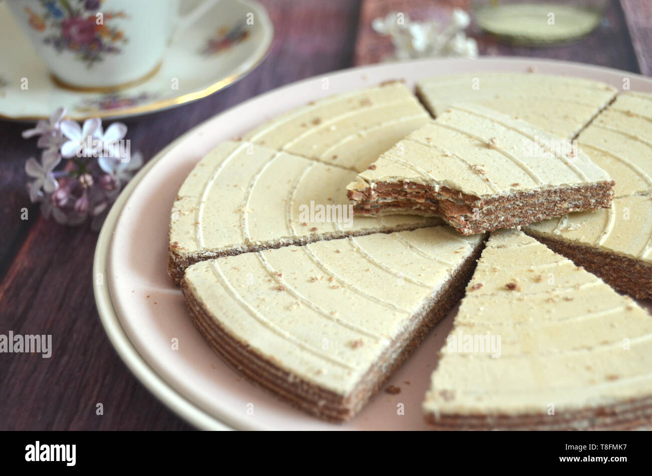 Original tschechische Kolonada spa waffer Dreiecke: Traditionelle Schokolade gefüllte Kekse, vintage Tasse Tee, lila Blüten Stockfoto