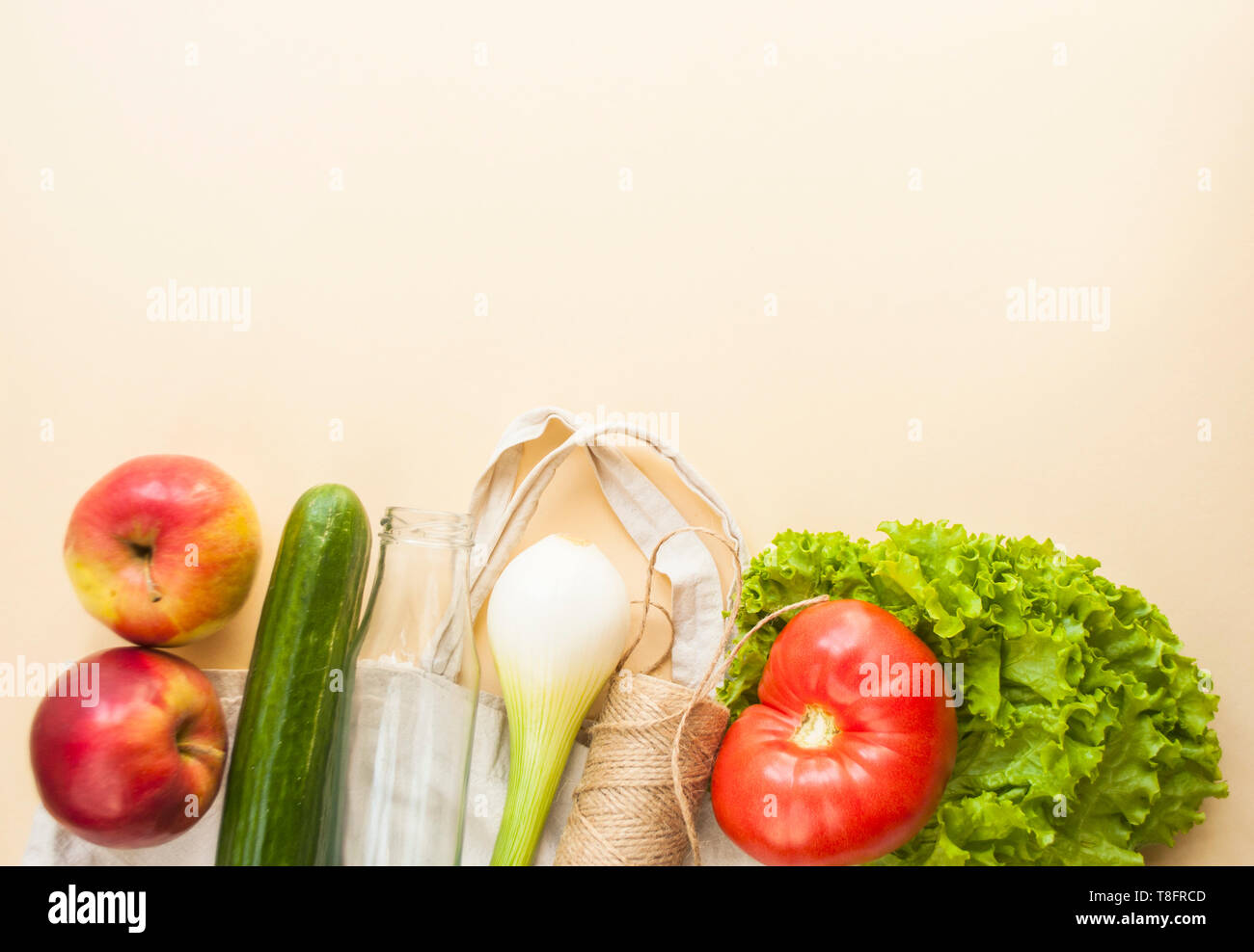 Frisches Obst und Gemüse im eco Beutel auf beige Farbe Hintergrund mit Copyspace. Kunststoff Konzept. Stockfoto
