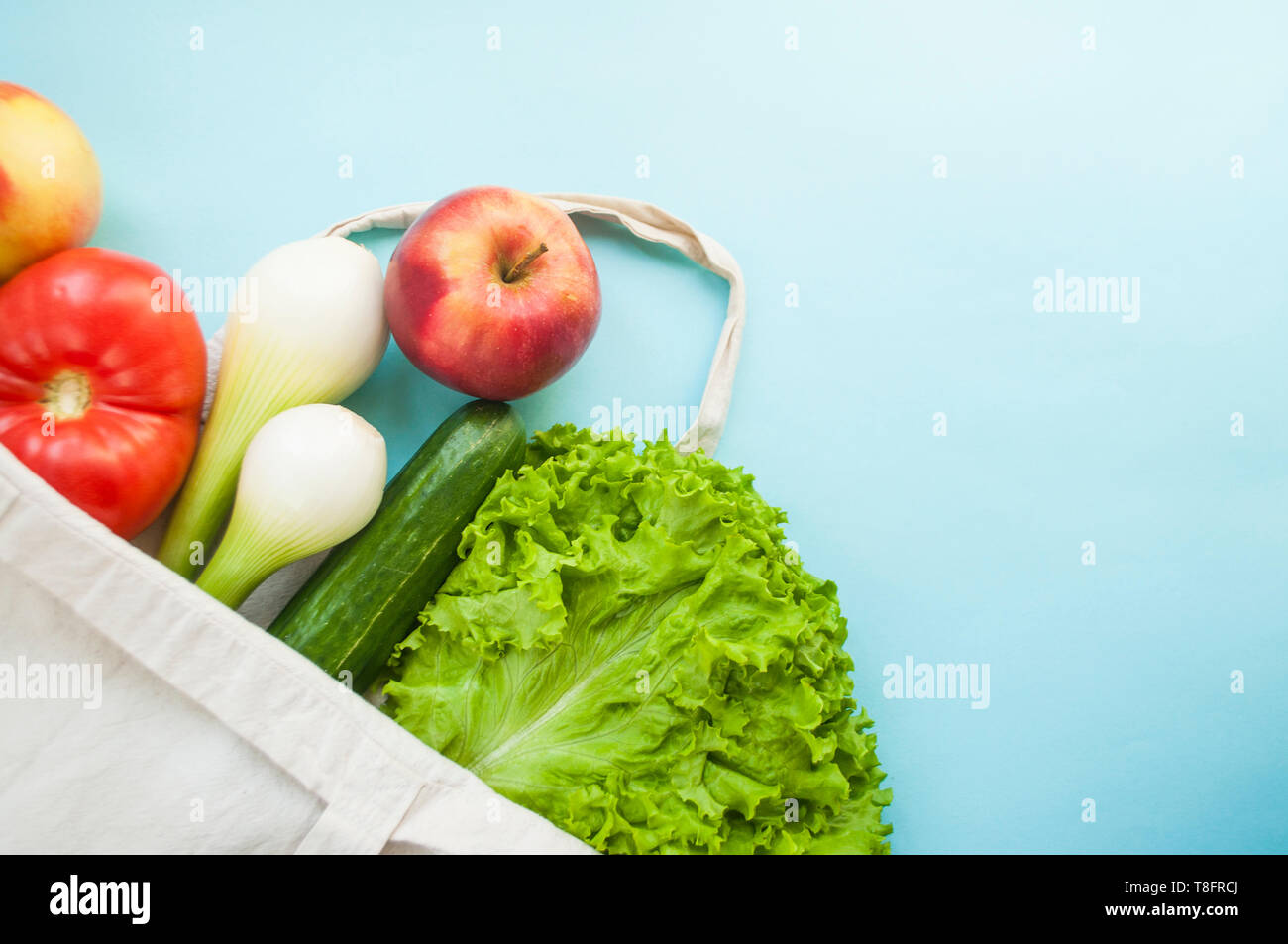 Frisches Obst und Gemüse im eco Beutel auf blaue Farbe Hintergrund mit Copyspace. Kunststoff Konzept. Stockfoto