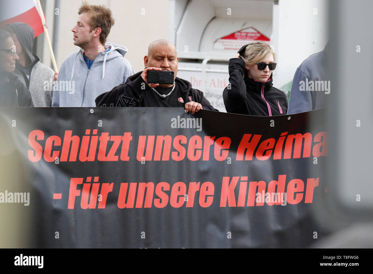 Pforzheim, Deutschland. 11. Mai, 2019. Ein rechter Demonstrant hält eine Fahne, die lautet: "Unsere Heimat - Schutz für unsere Kinder" und zeichnet die Rede bei der Kundgebung auf dem Smartphone. Rund 80 Menschen in einem Marsch durch Pforzheim, organisiert von der rechten Seite nahm Partei 'Die Rechte' (rechts). Die wichtigsten Fragen der März war die Förderung der Abstimmung für Rechte Sterben" in der bevorstehenden Europawahl und ihren Anti-Einwanderungspolitik. Sie wurden von mehreren hundert Zähler konfrontiert - Demonstranten aus verschiedenen politischen Organisationen. Quelle: Michael Debets/Pacific Press/Alamy leben Nachrichten Stockfoto