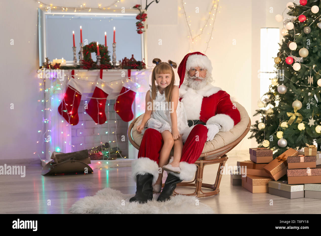 Santa Claus und nettes Mädchen im Zimmer für Weihnachten dekoriert Stockfoto