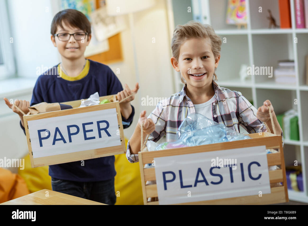 Gerne fleißige Kinder achtsam Verbrauch anzeigen, während Sie Boxen Stockfoto