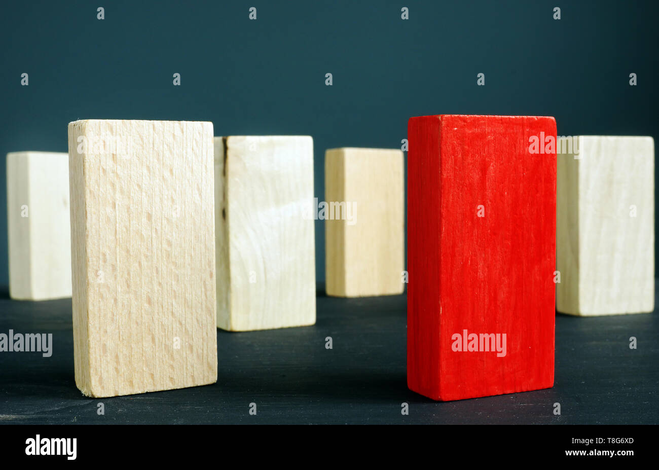 Verschiedene und einzigartige Konzept. Red Block und Holzklötze. Stockfoto