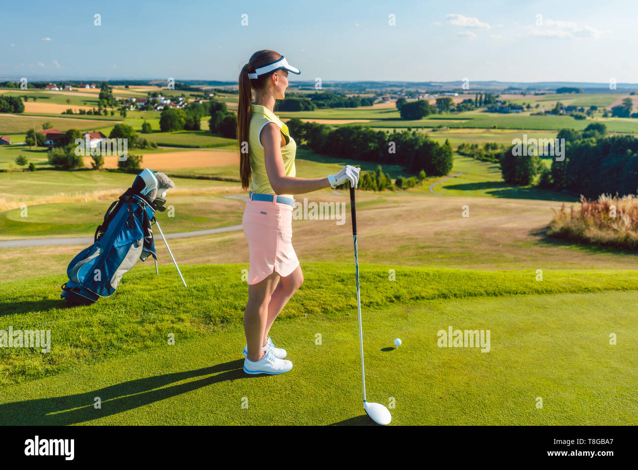 Passende Frau am Horizont auf der Suche auf dem grünen Rasen eines Golfplatzes Stockfoto