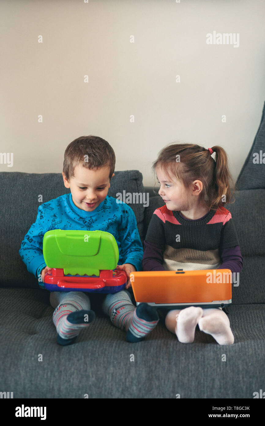 Zwei Kinder spielen mit Notebooks lernen grundlegende Ziffern, Zeichen ...