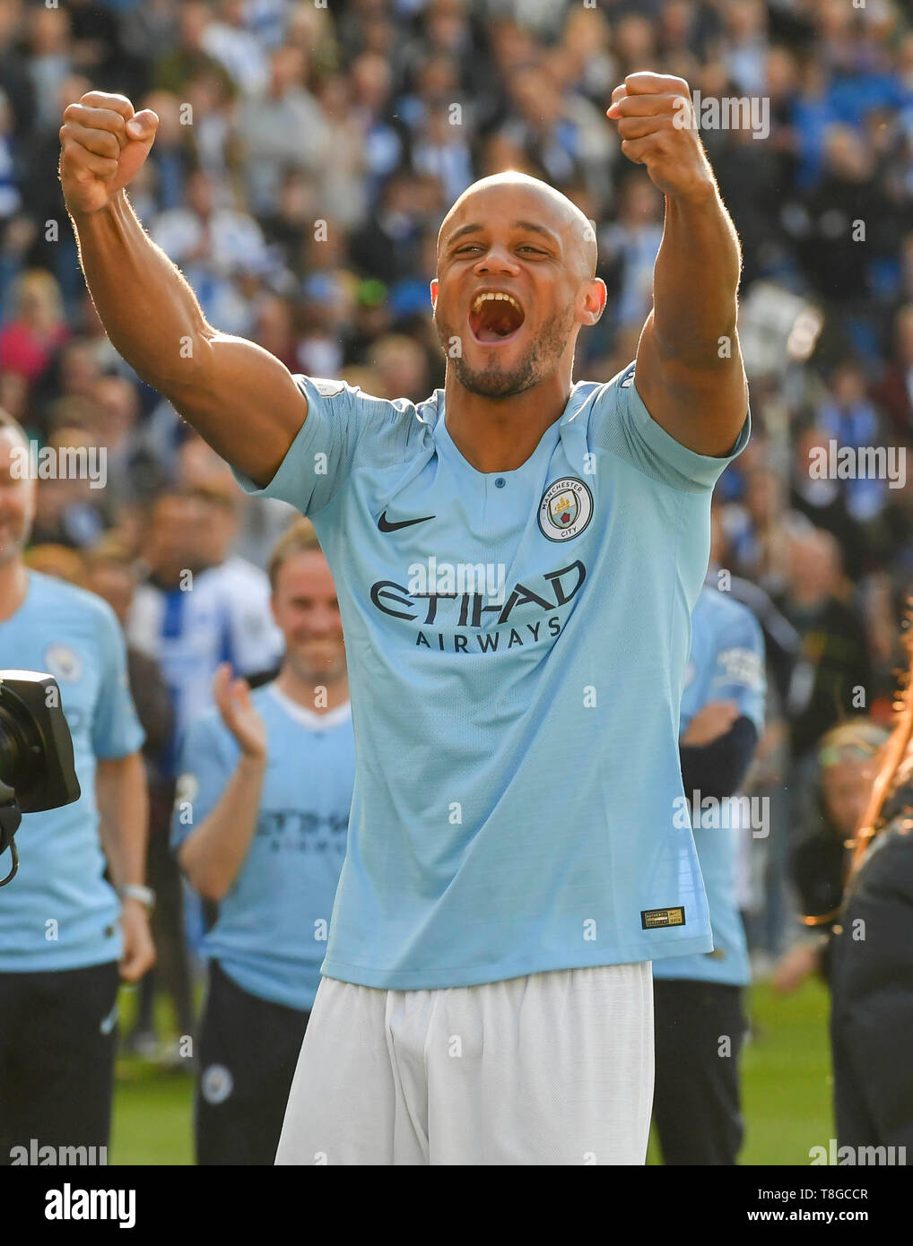 BRIGHTON, ENGLAND - Mai 12: Vincent Kompany (4), Manchester City feiert Vor der Stadt Fans, als er Spaziergänge seine Siegermedaille zu sammeln und die Premier League Trophy beim Premier League Spiel zwischen Brighton & Hove Albion und Manchester City bei American Express Gemeinschaft Stadion Lift am 12. Mai 2019 in Brighton, Großbritannien. (MB) Stockfoto
