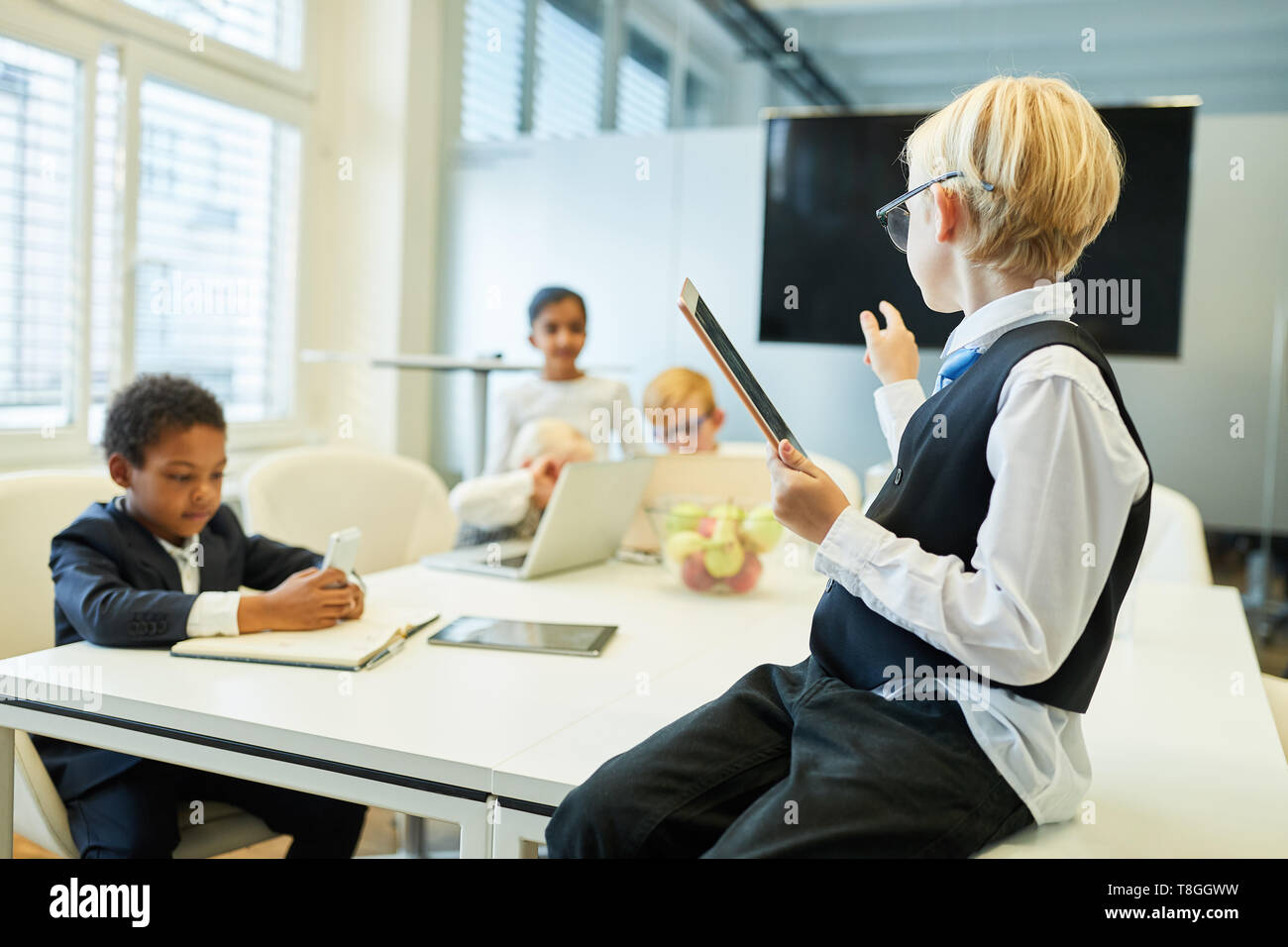 Kind als Business Consultant oder Manager mit Team in Consulting Workshop Stockfoto